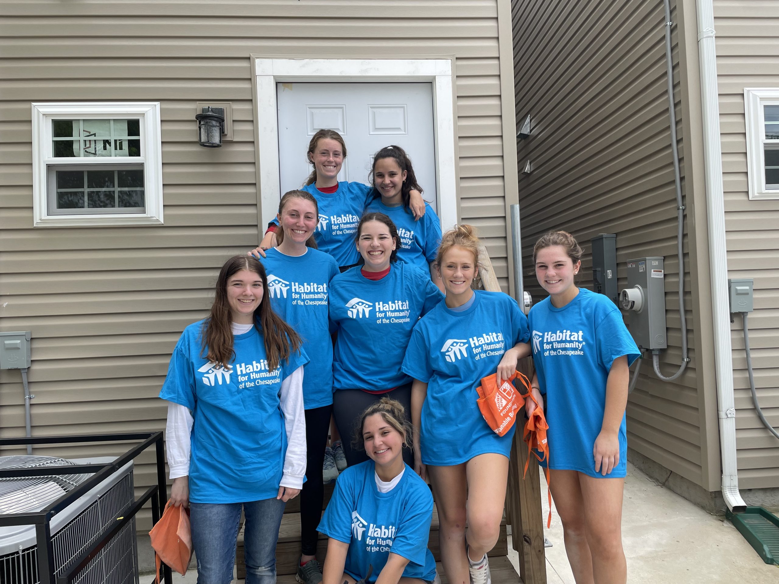 Group of youth volunteers smiling on the build site